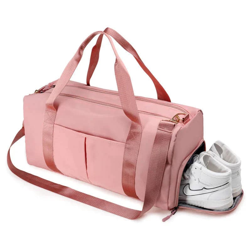 Pink sports and travel duffel bag with white sneakers in its separate zippered shoe compartment